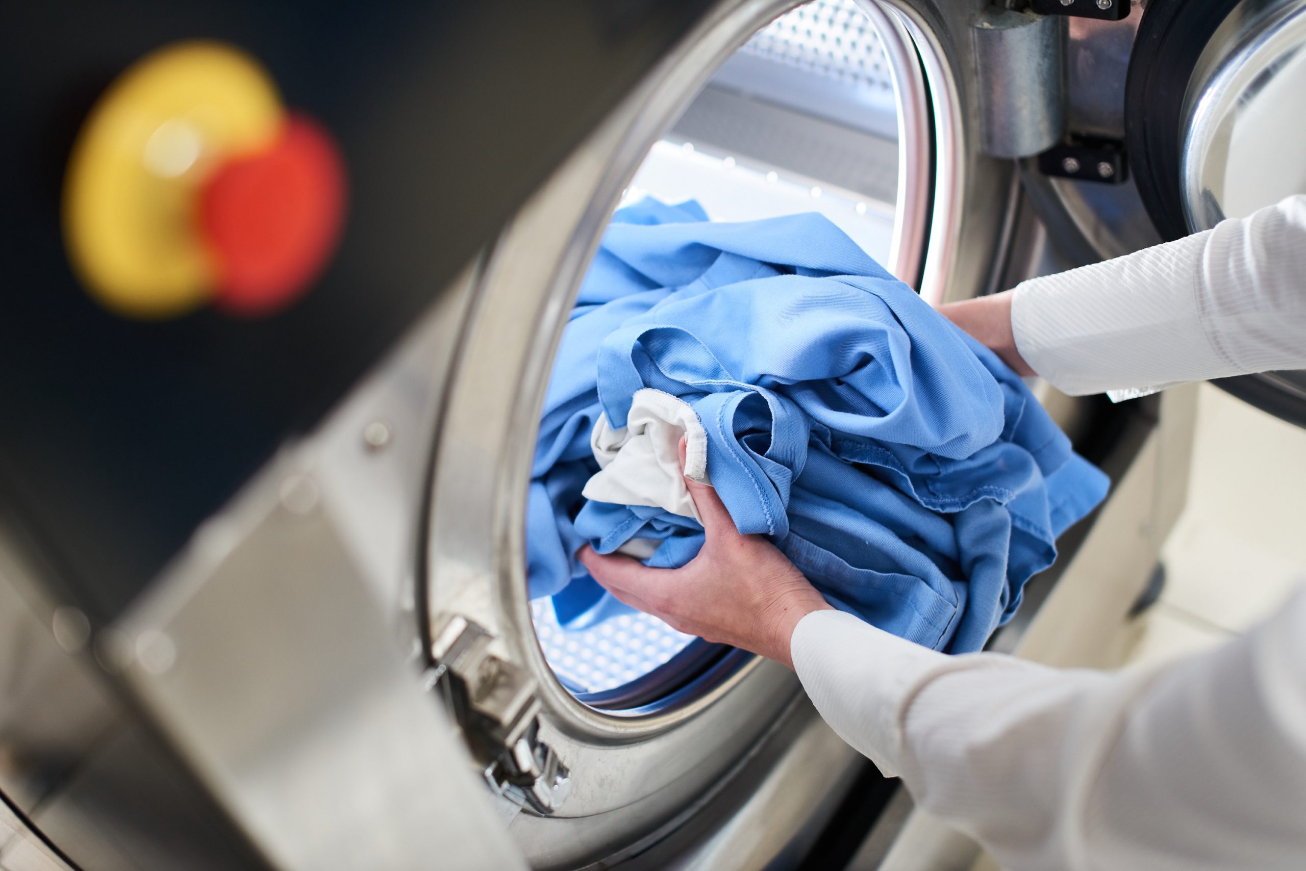 Hands,To,Load,The,Laundry,In,The,Washing,Machine,At